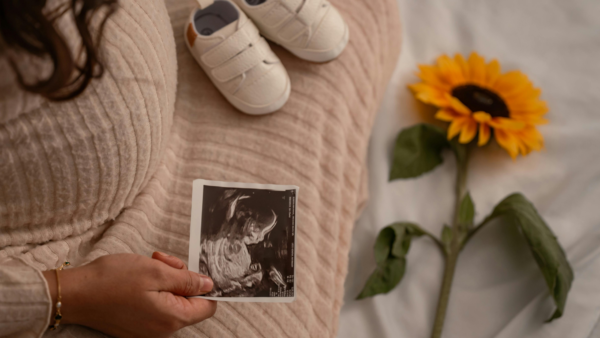 Mujer sosteniendo ecografía — deseo de maternidad y tratamiento de fertilidad