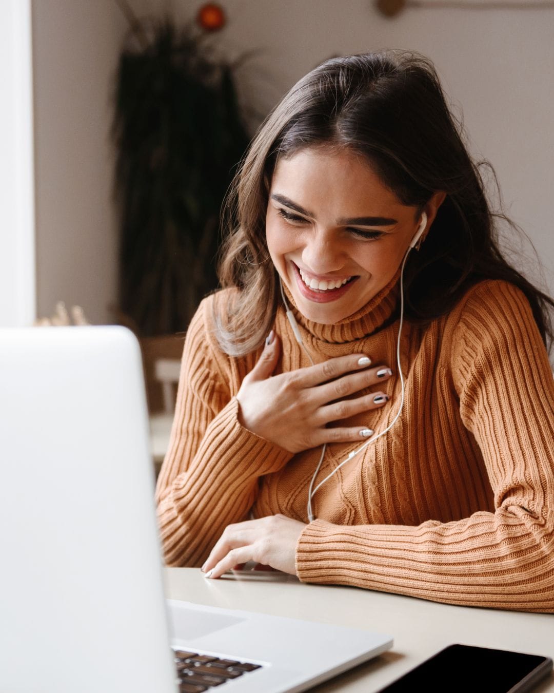Mujer sonriendo durante una videollamada de terapia online con un psicólogo en español